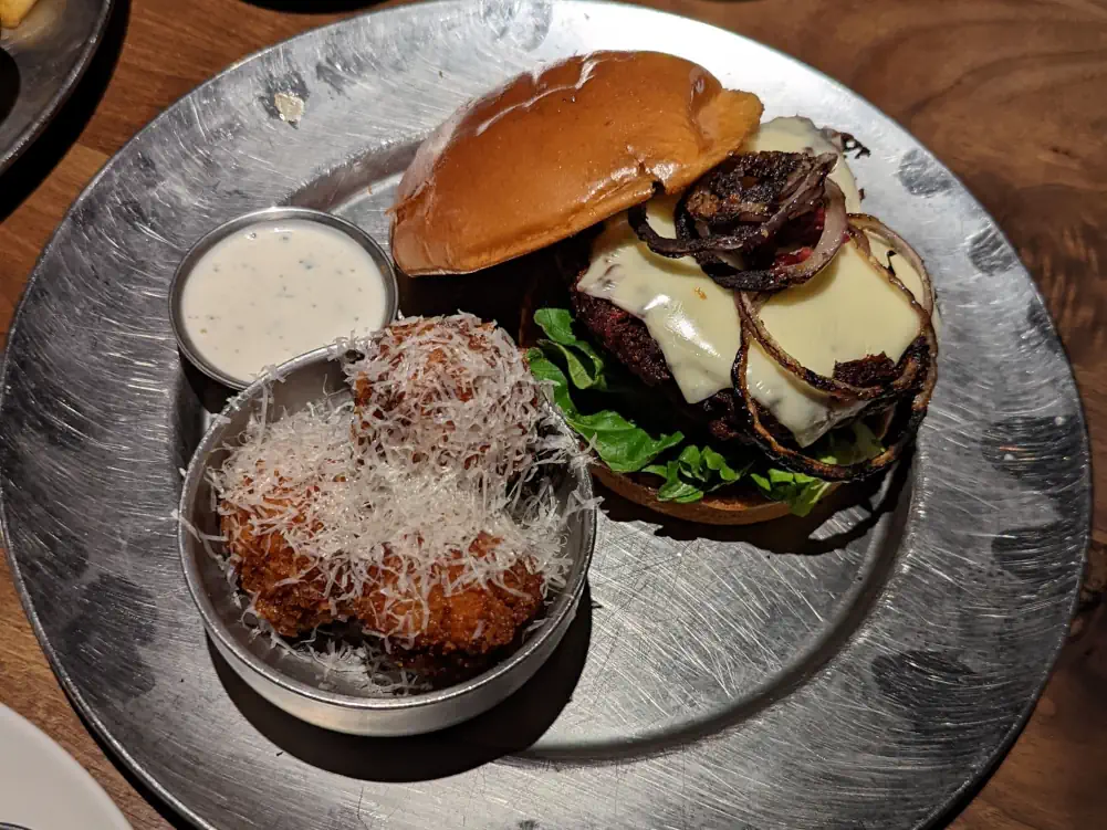 Assiette argentée contenant un hamburger avec sauce blanche, au sein du restaurant “Eureka! Discover American Craft” dans le Downtown de Las Vegas.