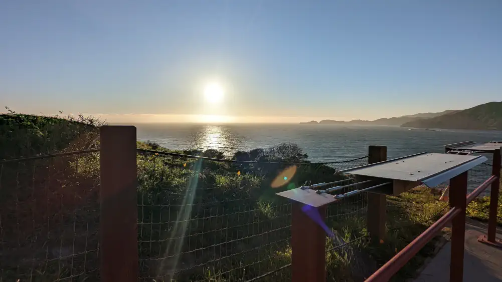 Coucher de soleil depuis l’un des points de vue à proximité du pont de San Francisco. La lumière se reflète sur l’océan.