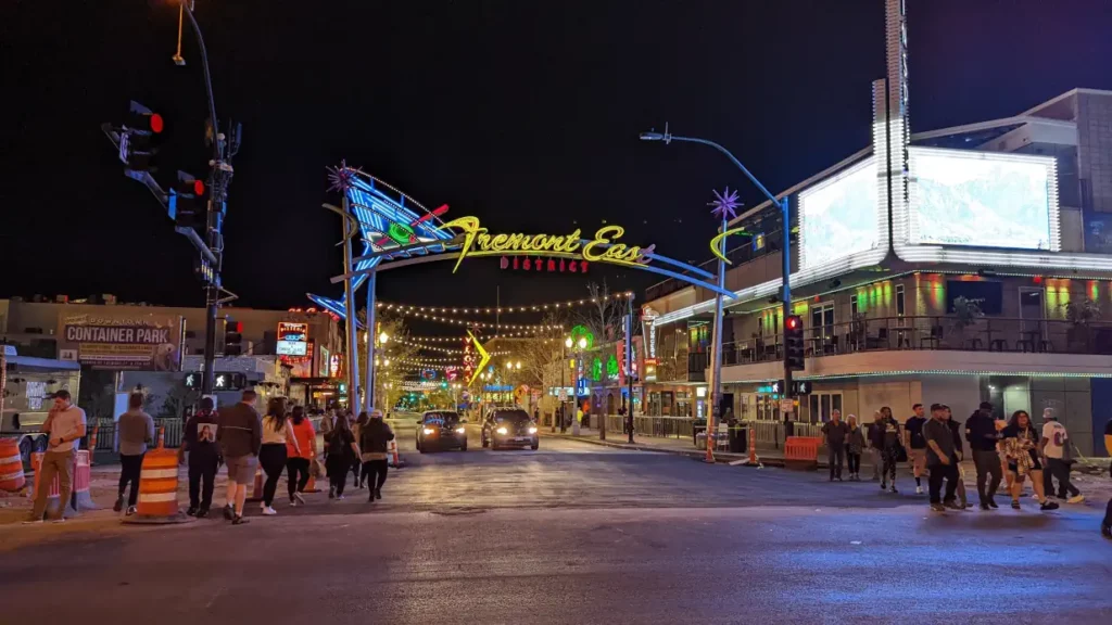 Panneau lumineux marquant l’entrée du quartier de Fremont East District à Las Vegas. La rue est éclairée et traversée par de nombreux touristes.