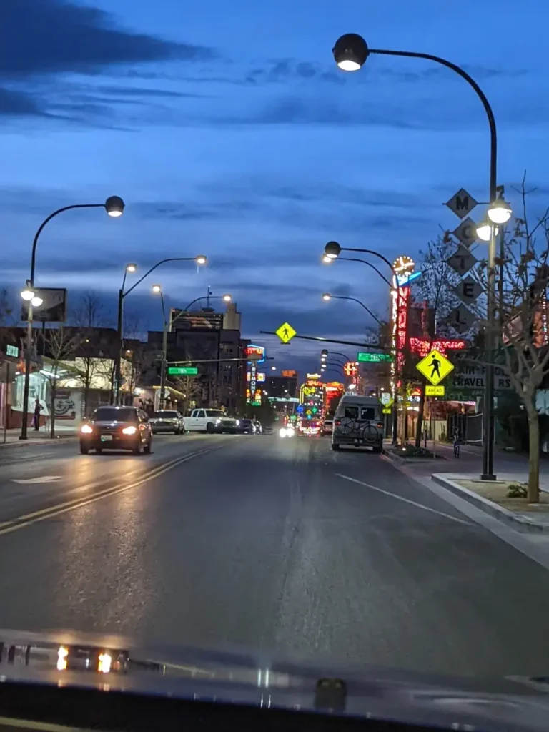 Aperçu de Fremont Street à travers le pare-brise d’une voiture. Il fait nuit et, au loin, des lumières font leur apparition.