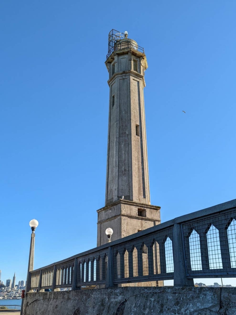 Vue en contre-plongée sur le phare de la prison d’Alcatraz. Une rambarde est située en premier plan.