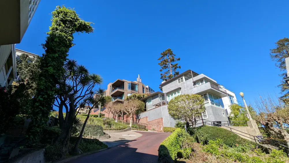 Vue en contre-plongée sur deux grandes maisons situées dans un virage de la portion en lacets de Lombard Street à San Francisco.