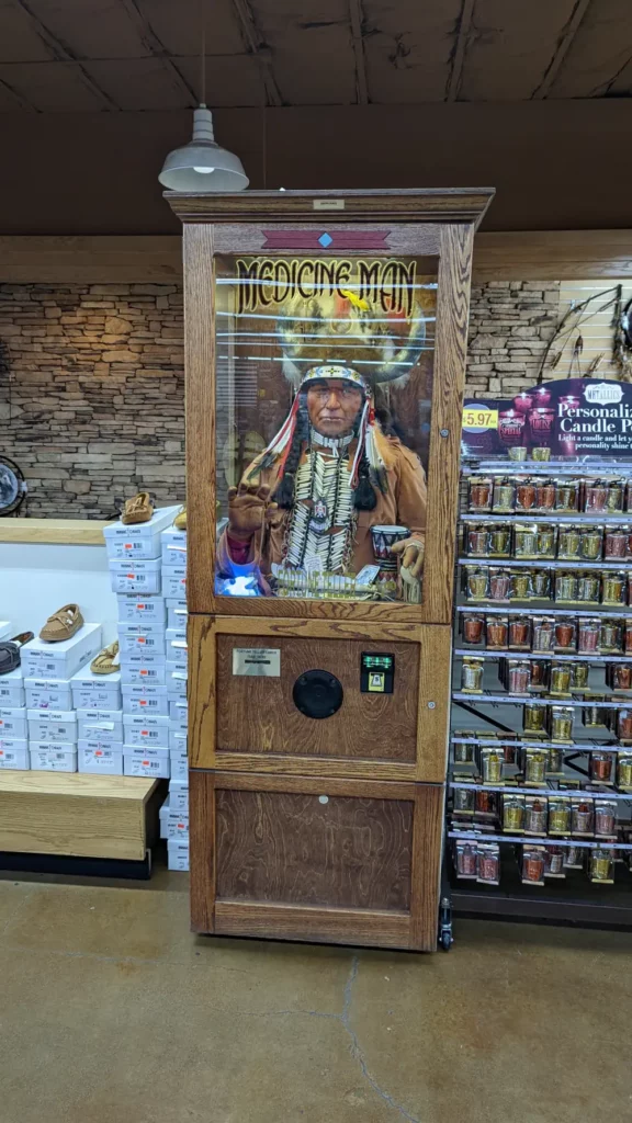 Portrait en pied de la machine “Medicine Man Fortune Teller”. Il s’agit d’une boîte en bois, contenant l’automate d’un homme en tenue d’indien.