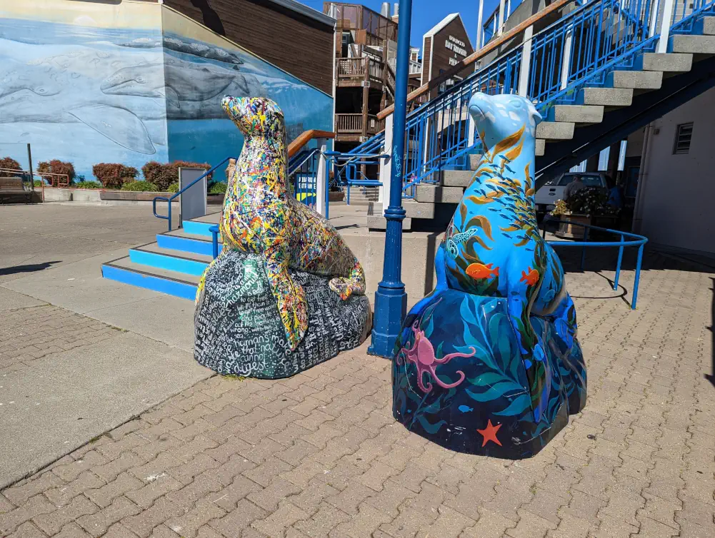 Deux statues de lions de mer au Pier 39. L’une est aux couleurs de la mer et l’autre est récouverte à la Jackson Pollock.