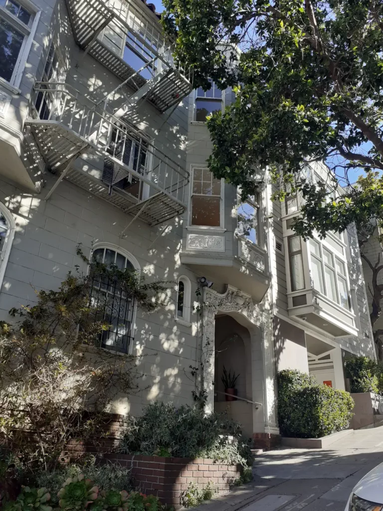 Façade blanche et verdoyante de la résidence Guesthouse dans le quartier de Nob Hill, idéale pour votre visite de San Francisco.