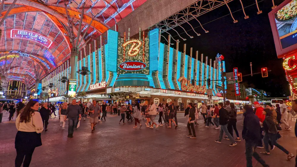 Façade illuminée bleue turquoise de l’hôtel “Binion's Gambling Hall & Hotel”, à l’intérieur de la Fremont Street Experience. Il est situé sur une place avec beaucoup de monde.