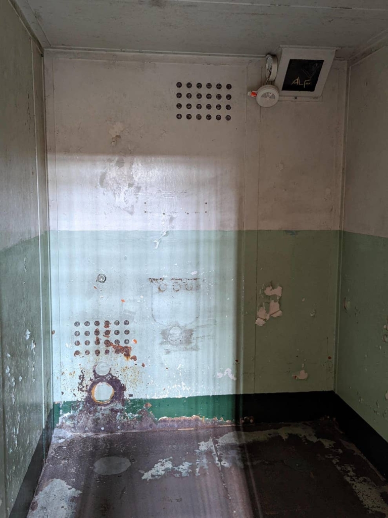 Intérieur d’une cellule réservée aux plus dangereux criminels de la prison d’Alcatraz. La pièce est vide et marquée par la rouille.