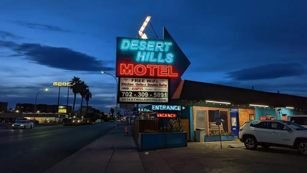 Panneau lumineux du Desert Hills Motel, sur la rue de Fremont Street. Il fait sombre et la nuit commence à tomber.