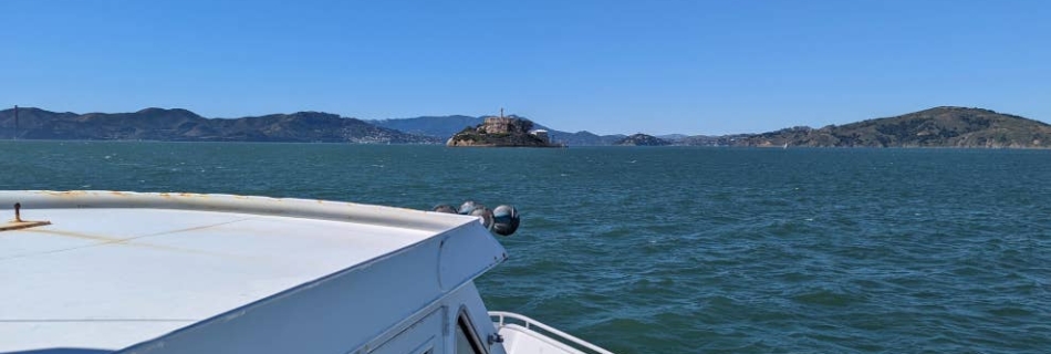 Vue sur Alcatraz à l'avant d'un ferry, sur la baie de San Francisco. D’ici, l’île est toute petite.