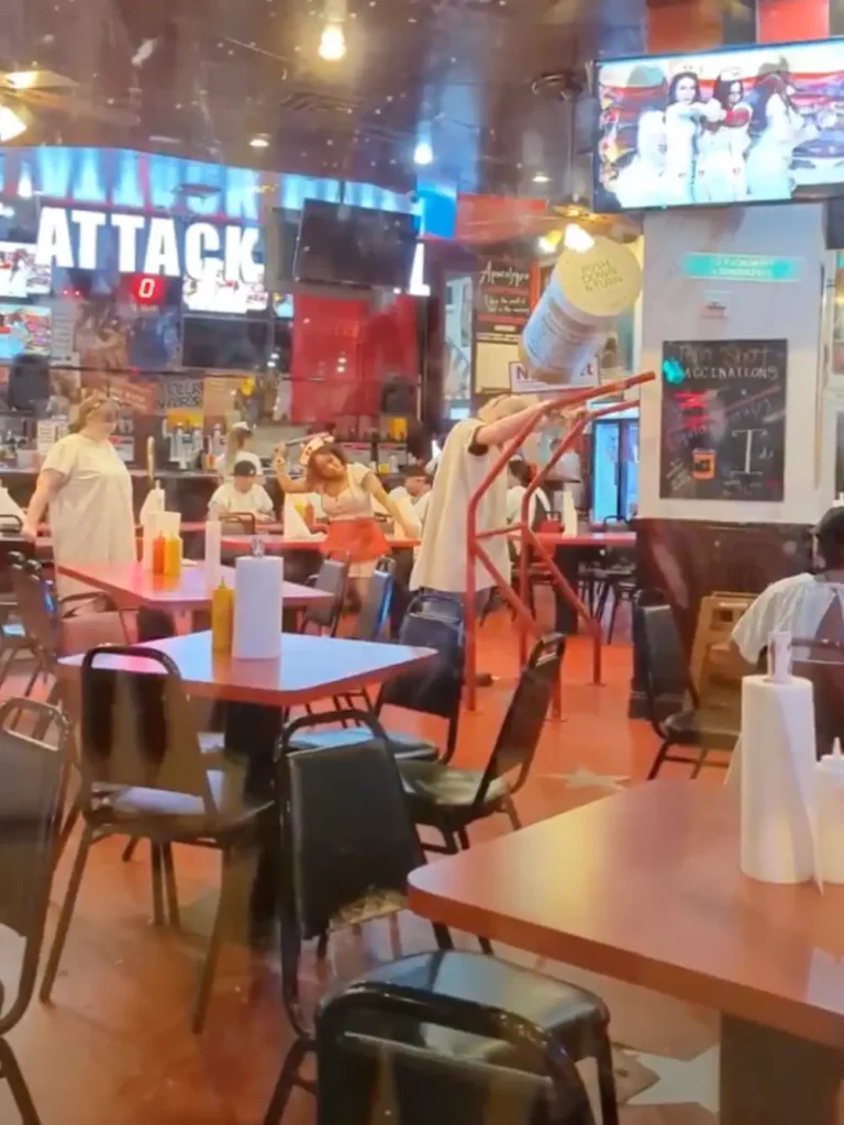 Intérieur du restaurant de hamburgers Heart Attack Grill, vu à travers une fenêtre depuis la Fremont Street Experience. Une infirmière est en train de fouetter un client.