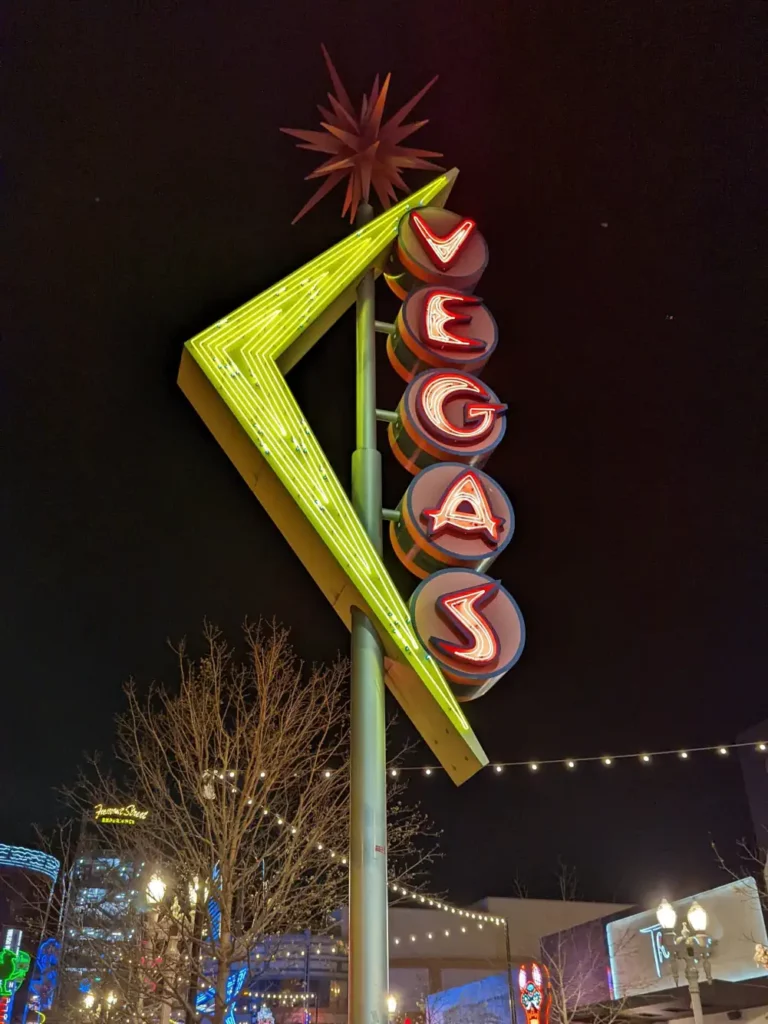 Panneau lumineux du district de E (East) Fremont Street, situé dans le quartier de Downtown. Il est jaune et rouge, avec les lettres “VEGAS”.