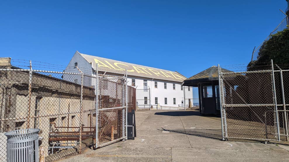 Bâtiment du quartier maître, situé derrière une grille. Sur le toit est peint en jaune le mot “ALCATRAZ”. 