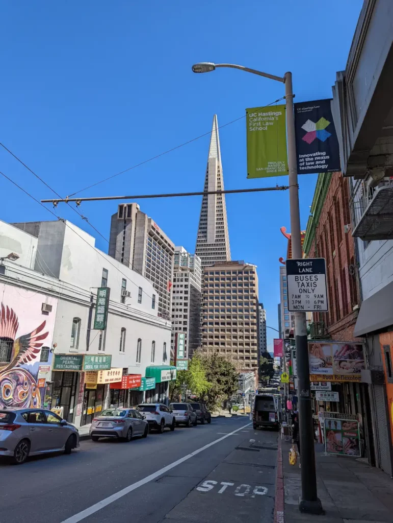 Vue sur le sommet de la tour Transamerica Pyramid, cachée par des immeubles, depuis une rue du quartier de Chinatown.