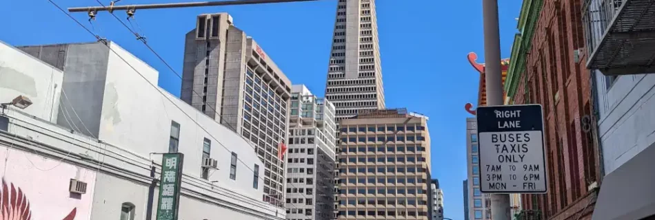 Vue sur le sommet de la tour Transamerica Pyramid, cachée par des immeubles, depuis une rue du quartier de Chinatown.