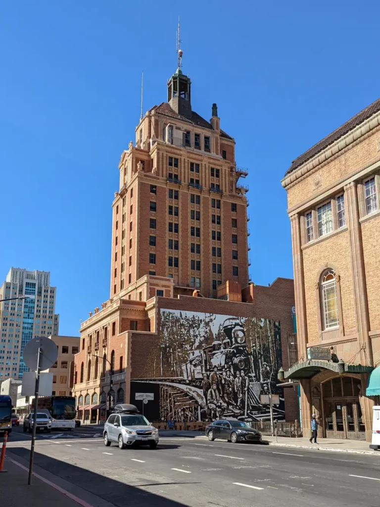 Bâtiment imposant et en briques de la “Elks Tower”. Sur la façade se trouve un graffiti avec une locomotive.