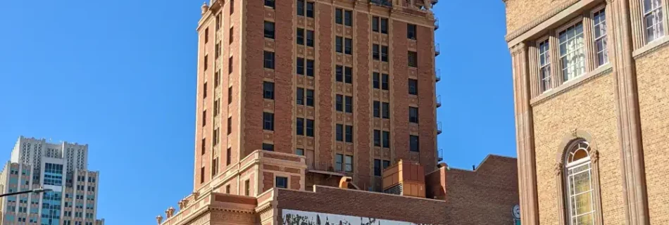 Bâtiment imposant et en briques de la “Elks Tower”. Sur la façade se trouve un graffiti avec une locomotive.