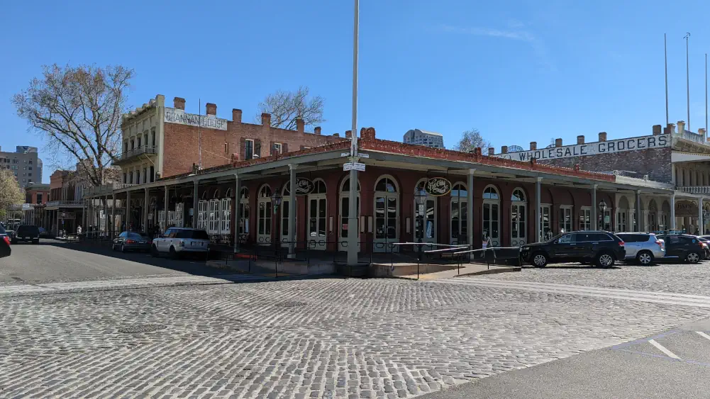 Bâtiment rouge et blanc sans étage, située dans un croisement pavé. C’est ici que se trouve le restaurant “Fat City Bar & Café”.