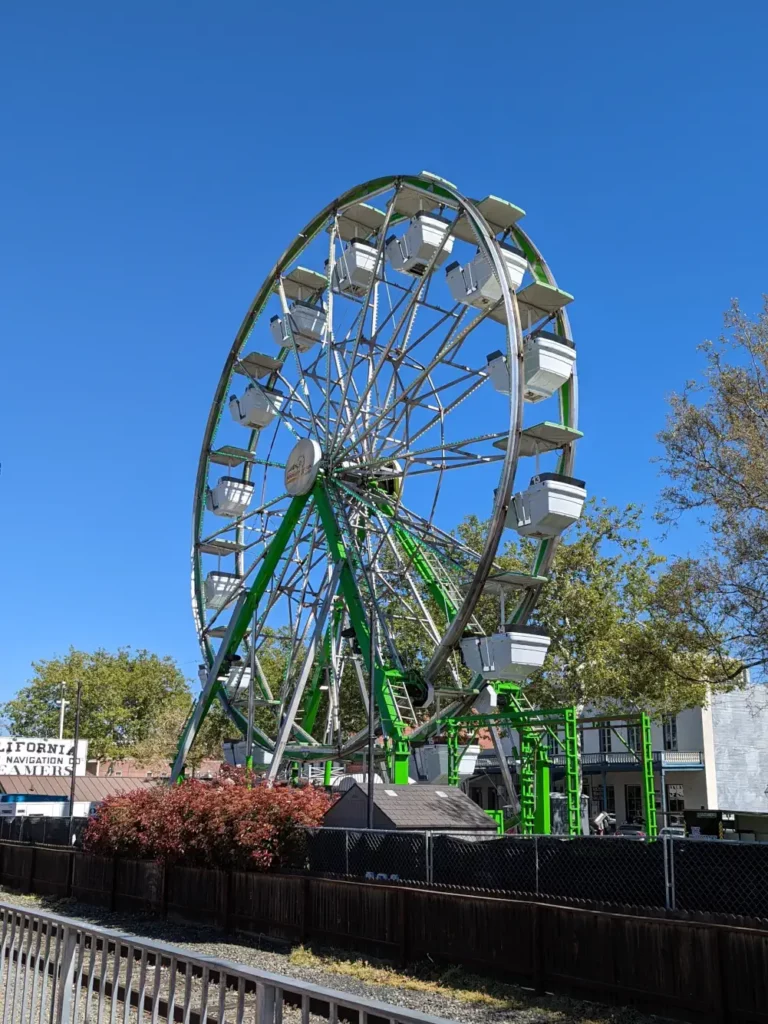 Vue trois-quart sur la “Waterfront Wheel”, grande roue verte et blanche emblématique de Sacramento.