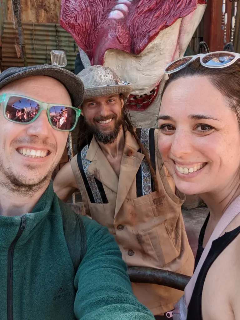 Selfie de Hélo et Nano avec le héros principal du spectacle Waterworld à Universal Studio LA. Derrière se trouve une carcasse.