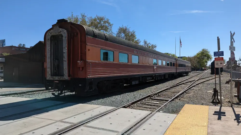 Passage à niveau sur lequel se trouve deux wagons du vieux train “Southern Pacific SP291”.