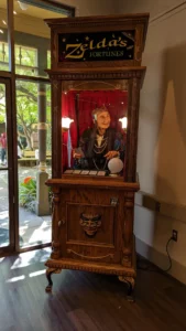 Portrait en pied de la fortune telling machine “Zelda’s Fortunes”. Elle est sculptée et tout en bois. A l’intérieur se trouve l’automate d’une vieille femme voyante.