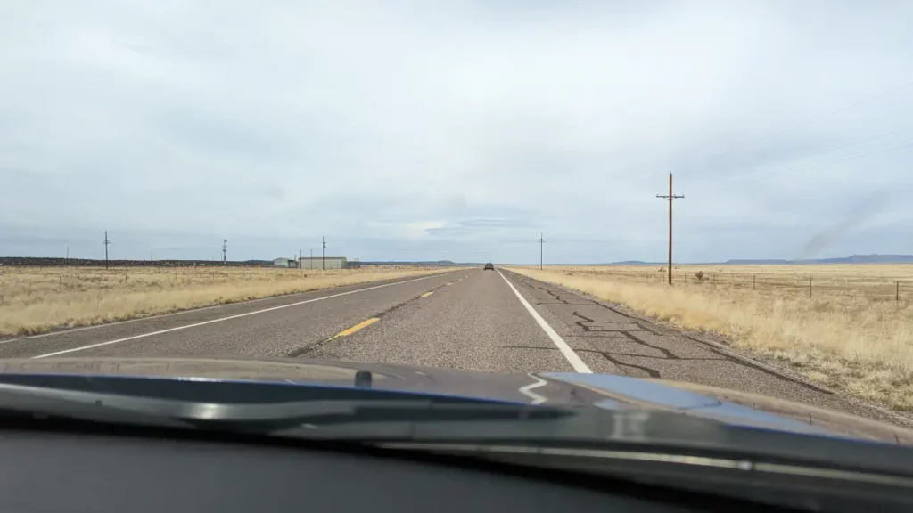 Route 66 aux USA, entourée d’un désert avec un horizon à perte de vue.