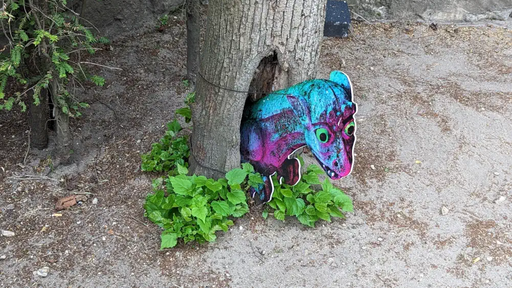 Tete d'une chimere qui dépasse du tronc d'un arbre