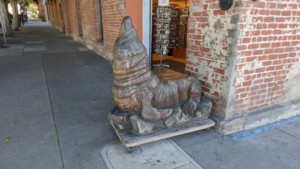 sculpture en bois d'un lion de mer devant une boutique